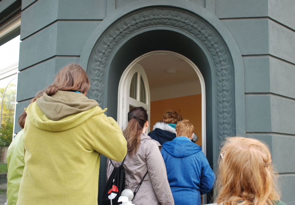 Menschen gehen durch die Eingangstür in den Nachbarschaftstreff Jüli 30